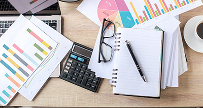 workspace with financial charts report calculator notebook pen and glasses 12 month analysis