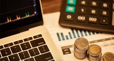 laptop calculator coins financial data analysis 11 investments growth trends